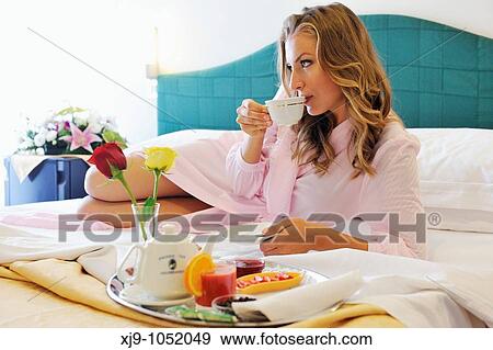 Young woman on bed in hotel room View Large Photo Image Stock Photo - Young woman on bed in hotel room. Fotosearch
