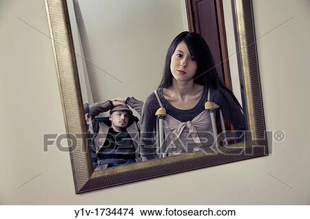 Young woman on crutches and boyfriend reflected in mirror View Large Photo Image Picture - Young woman on crutches and boyfriend reflected in mirror. Fotosearch