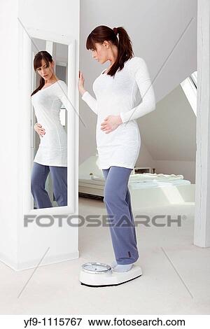 Stock Photo - Young woman on scale.. Fotosearch