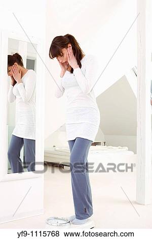 Stock Photo - Young woman on scale.. Fotosearch