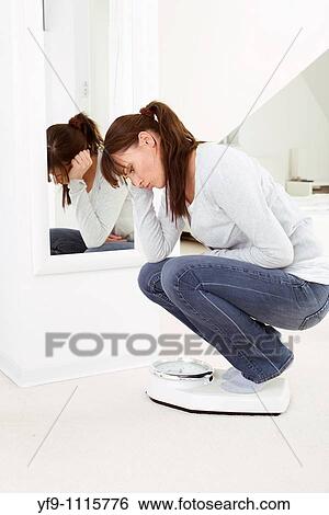 Stock Photograph - Young woman on scale.. Fotosearch