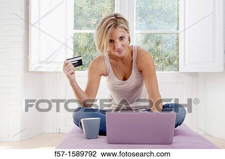 Stock Image - Young woman online shopping. Fotosearch