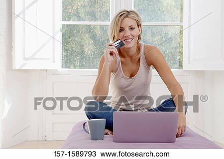 Stock Image - Young woman online shopping. Fotosearch