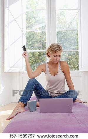 Stock Photo - Young woman online shopping. Fotosearch