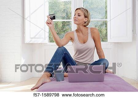 Stock Photo - Young woman online shopping. Fotosearch