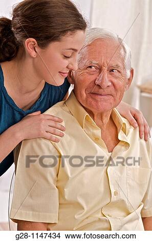 young woman or grand daughter or home help comforting a senior man View Large Photo Image Picture - young woman or grand daughter or home help comforting a senior man. Fotosearch