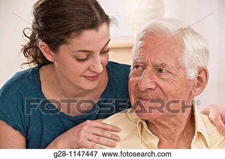 Stock Photo - Young woman or grand daughter showing tenderness and reassuring a senior person or grandfather. Fotosearch