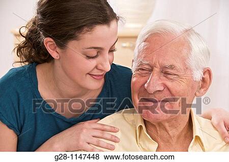Stock Photo - Young woman or grand daughter showing love tenderness for a senior person or grandfather. Fotosearch