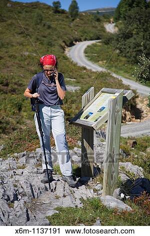 Stock Image - young woman outdoor with a cellphone Los Collados del Ason Natural Park Cantabria, Spain, Europe. Fotosearch