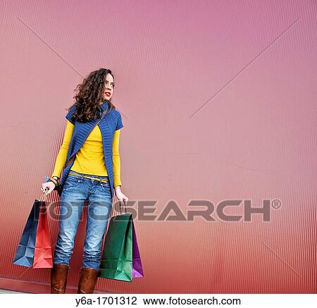 Stock Image - Young woman outdoors with shopping bags. Fotosearch