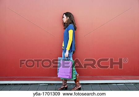 Stock Photo - Young woman outdoors with shopping bags. Fotosearch