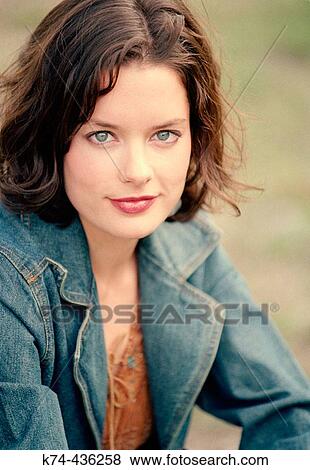Young woman outside in field View Large Photo Image Stock Photo - Young woman outside in field. Fotosearch