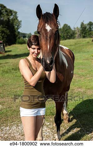Young woman petting a horse View Large Photo Image Stock Image - Young woman petting a horse. Fotosearch