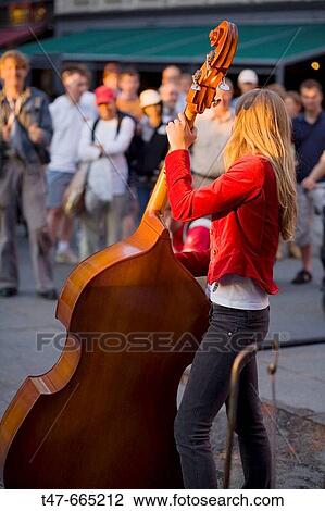 Young woman playing double bass in a centric street. Oslo. Norway. View Large Photo Image Stock Image - Young woman playing double bass in a centric street. Oslo. Norway.. Fotosearch