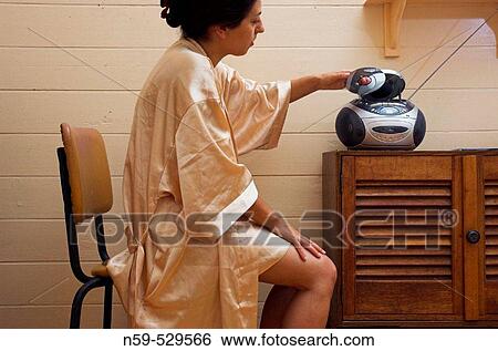 Stock Photograph - Young woman playing music at home.. Fotosearch