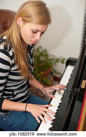 Young woman playing piano View Large Photo Image Stock Photo - Young woman playing piano. Fotosearch