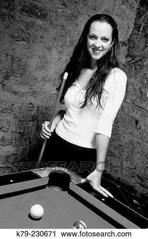 Stock Image - Young woman playing pool. Fotosearch