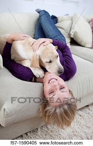 Young woman playing with her dog on the sofa View Large Photo Image Stock Photography - Young woman playing with her dog on the sofa. Fotosearch
