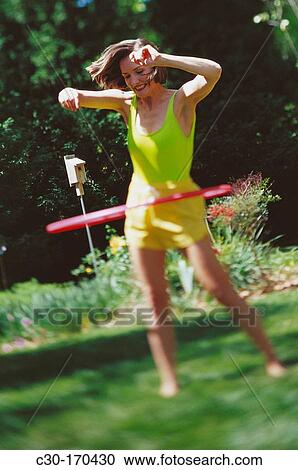 Young woman playing with hula-hoop View Large Photo Image Stock Image - Young woman playing with hula-hoop. Fotosearch