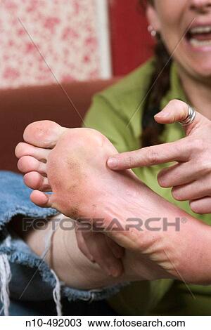 Young woman pointing to her foot View Large Photo Image Stock Image - Young woman pointing to her foot. Fotosearch