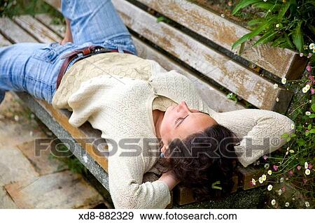 Young woman portrait resting on a bench View Large Photo Image Stock Photo - Young woman portrait resting on a bench. Fotosearch