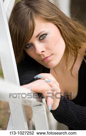 Young woman portrait resting on a fence View Large Photo Image Stock Image - Young woman portrait resting on a fence. Fotosearch