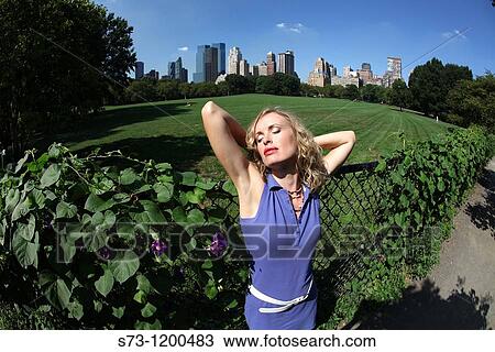 Stock Image - Young woman poses in Central Park, New York, USA. Fotosearch