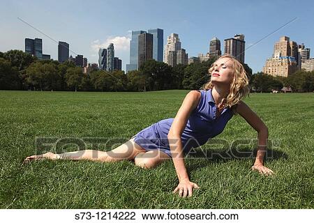 Stock Image - Young woman poses in Central Park, New York, USA. Fotosearch