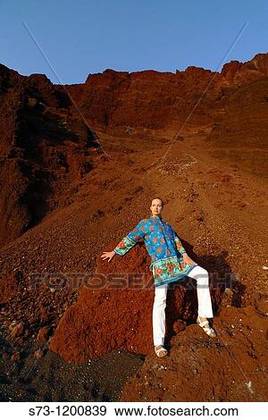 Stock Photo - Young woman poses in the Red Beach in Santorini, Cyclades Islands, Greece. Fotosearch