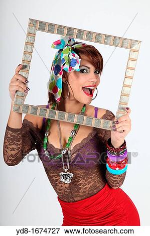 Young woman posing happy through a special frame in the Studio View Large Photo Image Stock Photo - Young woman posing happy through a special frame in the Studio. Fotosearch