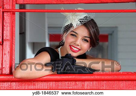 Stock Photo - Young woman posing in the window and looking at the camera from one of the trains of the Gold Coast Railroad Museum, Miami, Florida, USA. Fotosearch