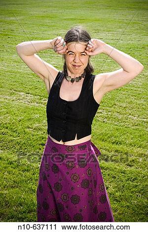 Young woman posing on the grass at a park. View Large Photo Image Stock Image - Young woman posing on the grass at a park.. Fotosearch