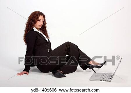 Young woman posing sitting in the studio as an executive with laptop View Large Photo Image Stock Photograph - Young woman posing sitting in the studio as an executive with laptop. Fotosearch