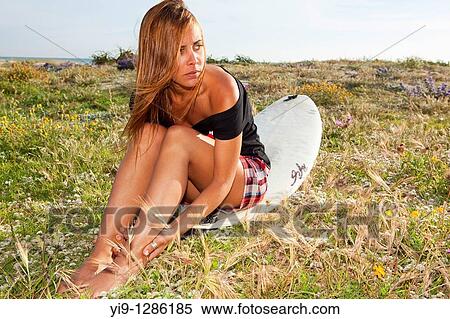 Stock Photography - Young woman posing with surfboard. Fotosearch
