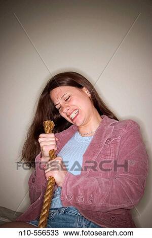 Stock Image - Young woman pulling on a rope.. Fotosearch