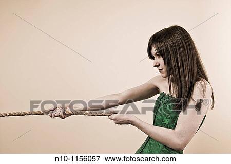 Stock Photo - Young woman pulling on the end of a rope. Fotosearch