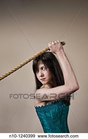 Stock Photo - Young woman pulling on the end of a rope. Fotosearch