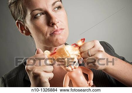 Young woman pulling the hair on a baby doll View Large Photo Image Picture - Young woman pulling the hair on a baby doll. Fotosearch