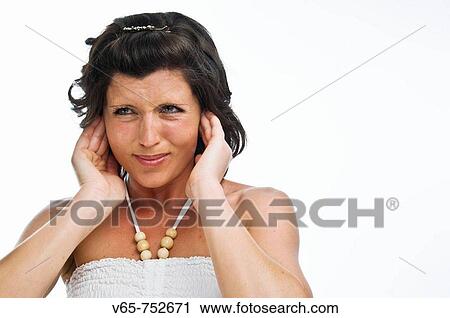 Stock Image - young woman putting her fingers in her ears to reduce the noise around her - suffering from tinitus or noise pollution. Fotosearch