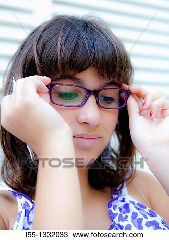 Young woman putting her glasses on View Large Photo Image Stock Image - Young woman putting her glasses on. Fotosearch