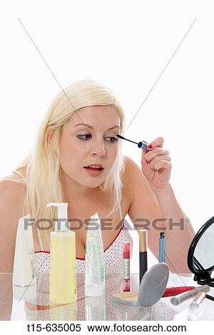 Young woman putting on makeup, eye lashes View Large Photo Image Stock Photography - Young woman putting on makeup, eye lashes. Fotosearch