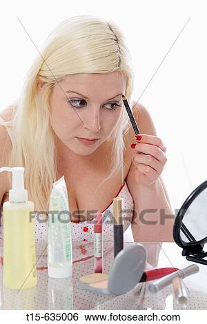 Young woman putting on makeup using eye brow pencil View Large Photo Image Stock Photograph - Young woman putting on makeup using eye brow pencil. Fotosearch
