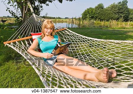 Young woman reading a magazine in a hammock, Germany, Europe View Large Photo Image Stock Photo - Young woman reading a magazine in a hammock, Germany, Europe. Fotosearch
