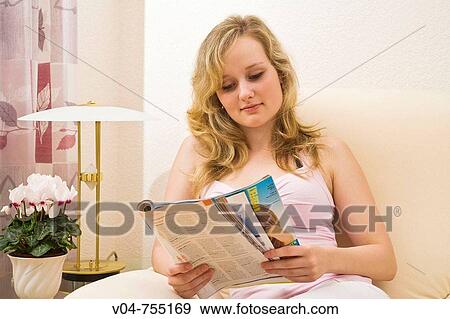 Young woman reading a magazine View Large Photo Image Stock Photo - Young woman reading a magazine. Fotosearch