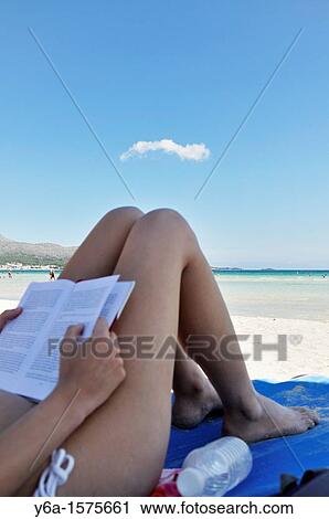 Young woman reading book on beach View Large Photo Image Stock Image - Young woman reading book on beach. Fotosearch