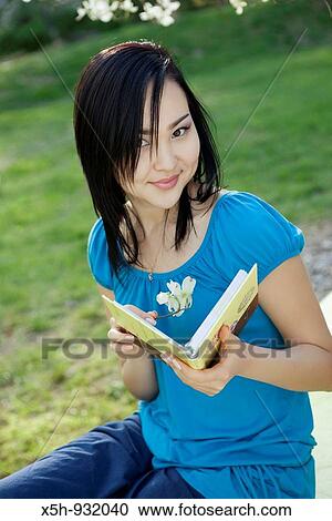 young woman reading book outdoor View Large Photo Image Stock Image - young woman reading book outdoor. Fotosearch