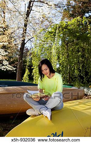 young woman reading book outdoor View Large Photo Image Stock Photograph - young woman reading book outdoor. Fotosearch