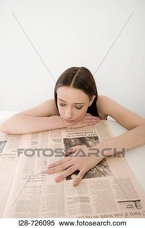 Young woman reading newspaper, close-up View Large Photo Image Stock Photography - Young woman reading newspaper, close-up. Fotosearch