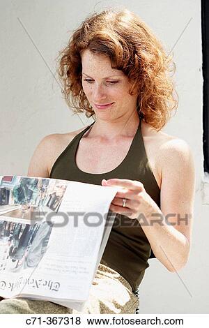 Young woman reading newspaper View Large Photo Image Stock Photo - Young woman reading newspaper. Fotosearch