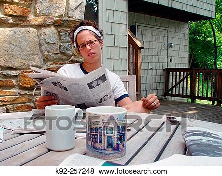 Young woman reading newspaper View Large Photo Image Stock Photo - Young woman reading newspaper. Fotosearch